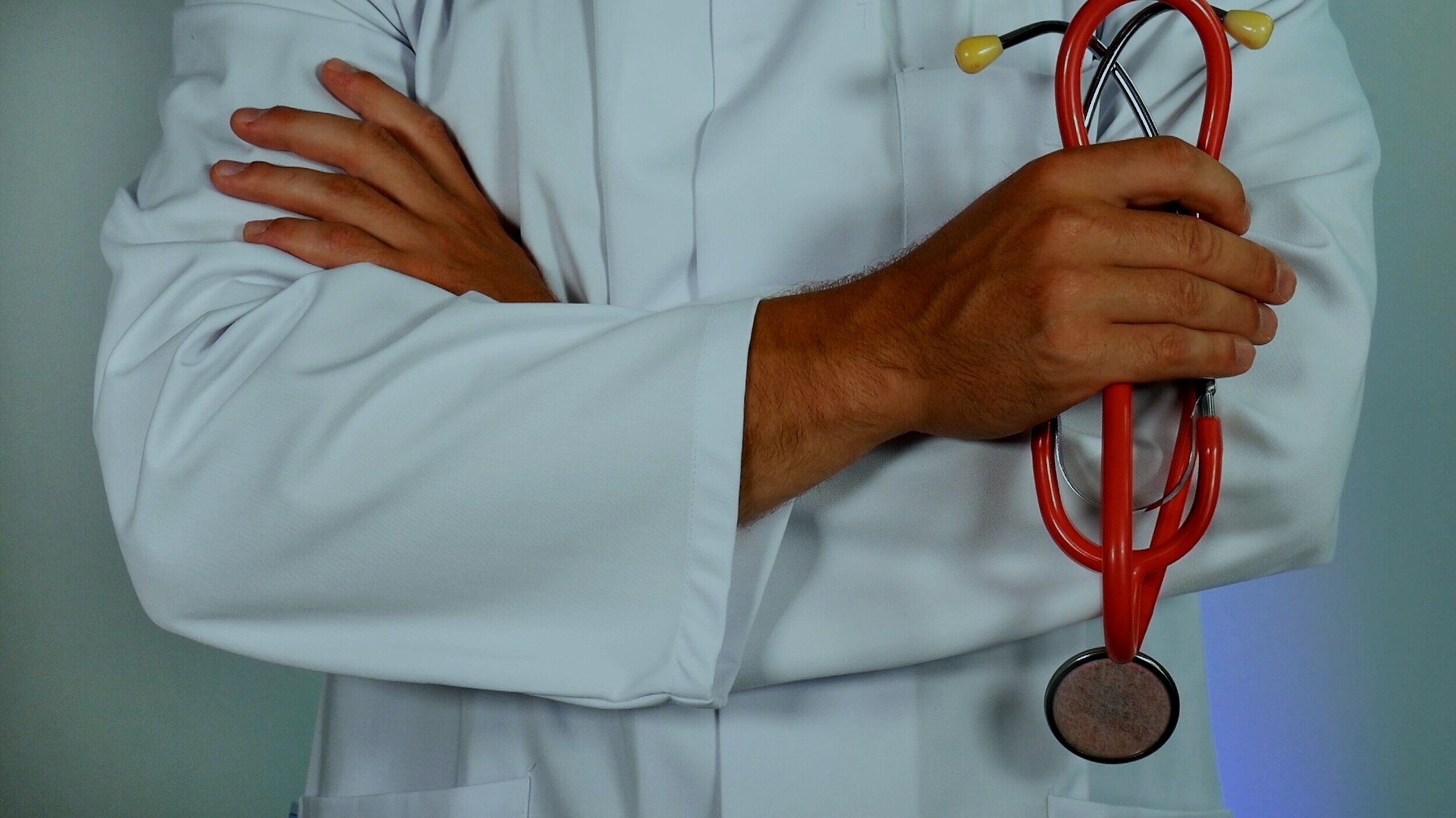 doctor in coat holding stethoscope